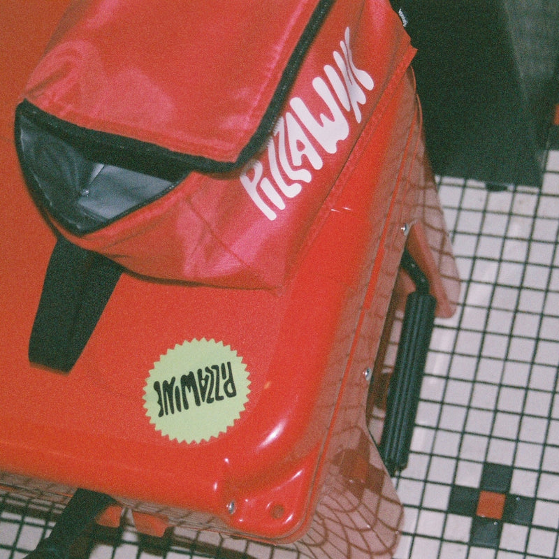 The red Pizza Wine cooler on a checkered tile floor