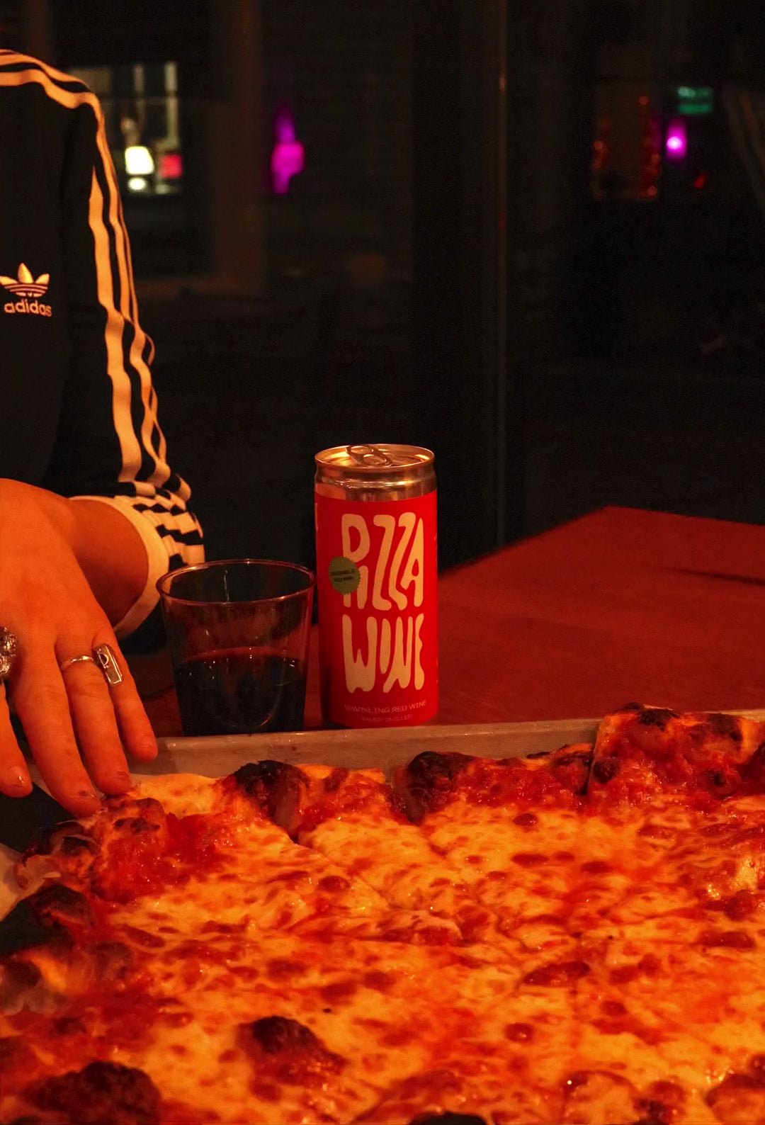 Grabbing a slice of cheese pizza next to a can of Pizza Wine at Jeff's Pizza